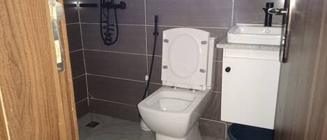 Un baño pequeño con inodoro, lavabo y ducha.