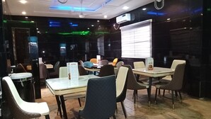 A restaurant with marble flooring, modern chairs, and tables. - Dutse Suites and Luxury (Abuja)