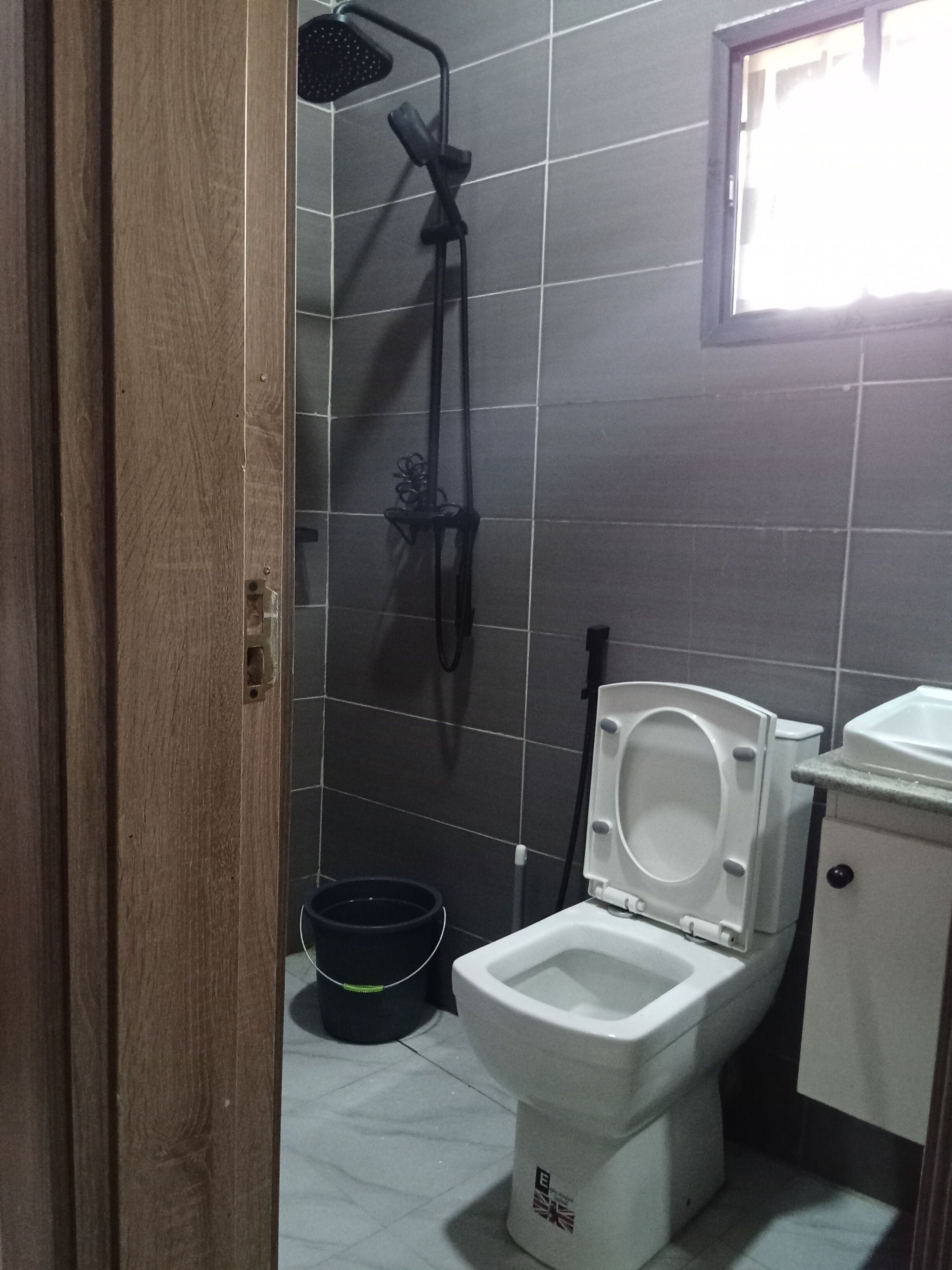 Un bagno con doccia, WC e lavandino.