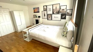 A bedroom with a bed, a desk, and a wardrobe. There are framed pictures on the wall. - Charming studio apartment in Central London W2 (London)