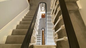 A staircase with a black handrail and white balusters, leading to a wooden door at the top. - Charming studio apartment in Central London W2 (London)