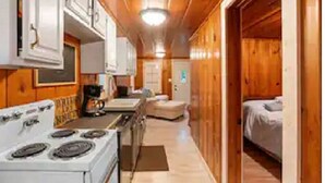 A compact kitchen with a stove, cabinets, and a countertop.