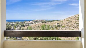 A balcony with a view of a coastal landscape, including a hill, trees, and the sea. - Nice Seaview 2 Bed 2 Bath Apartm. (Benalmádena)