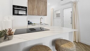 A modern kitchen with a built-in oven, a sink, and a large island. - Casa Rija Mijas village by Casa del sol (Mijas)