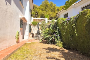 A patio with outdoor furniture, a white wall, and a hedge. - Buenavista 4 bed-room by Casa del sol HR (Málaga)