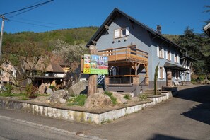 A two-story building with a balcony, a signboard advertising '4 CITES GRAND STANDING', and a telephone number.