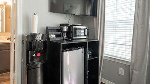 Une petite cuisine équipée d’une machine à café, d’un four à micro-ondes et d’un réfrigérateur.