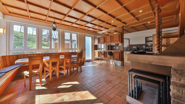 Un vaste espace dédié à la salle à manger, avec des meubles en bois et de grandes fenêtres.