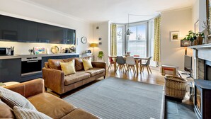 Una sala de estar moderna con un sofá, una mesa de comedor y una chimenea.