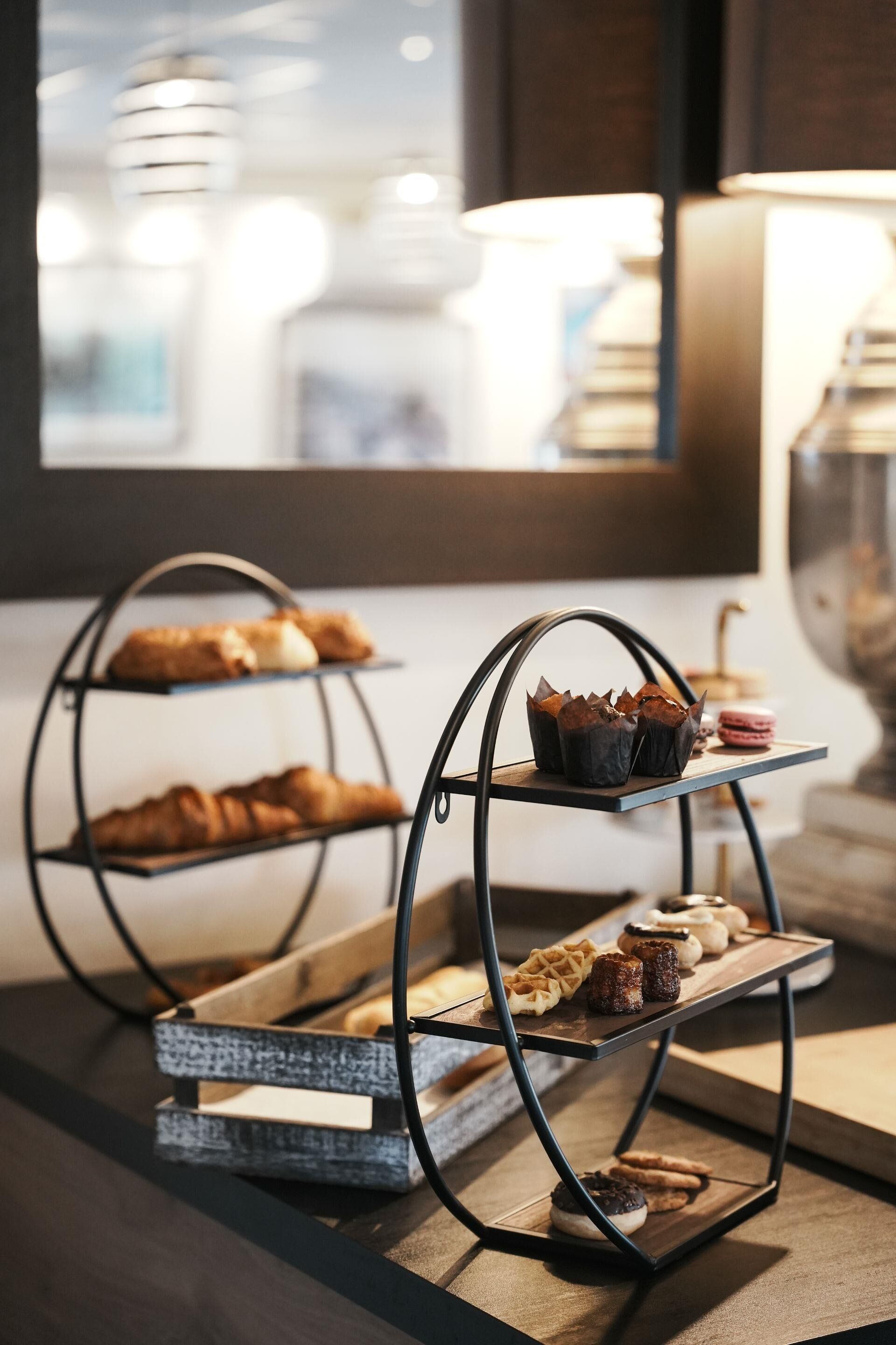 A dessert display with various pastries and macarons on a metal stand.