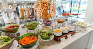 Un buffet proposant une variété de plats et agrémenté d’une composition florale décorative.