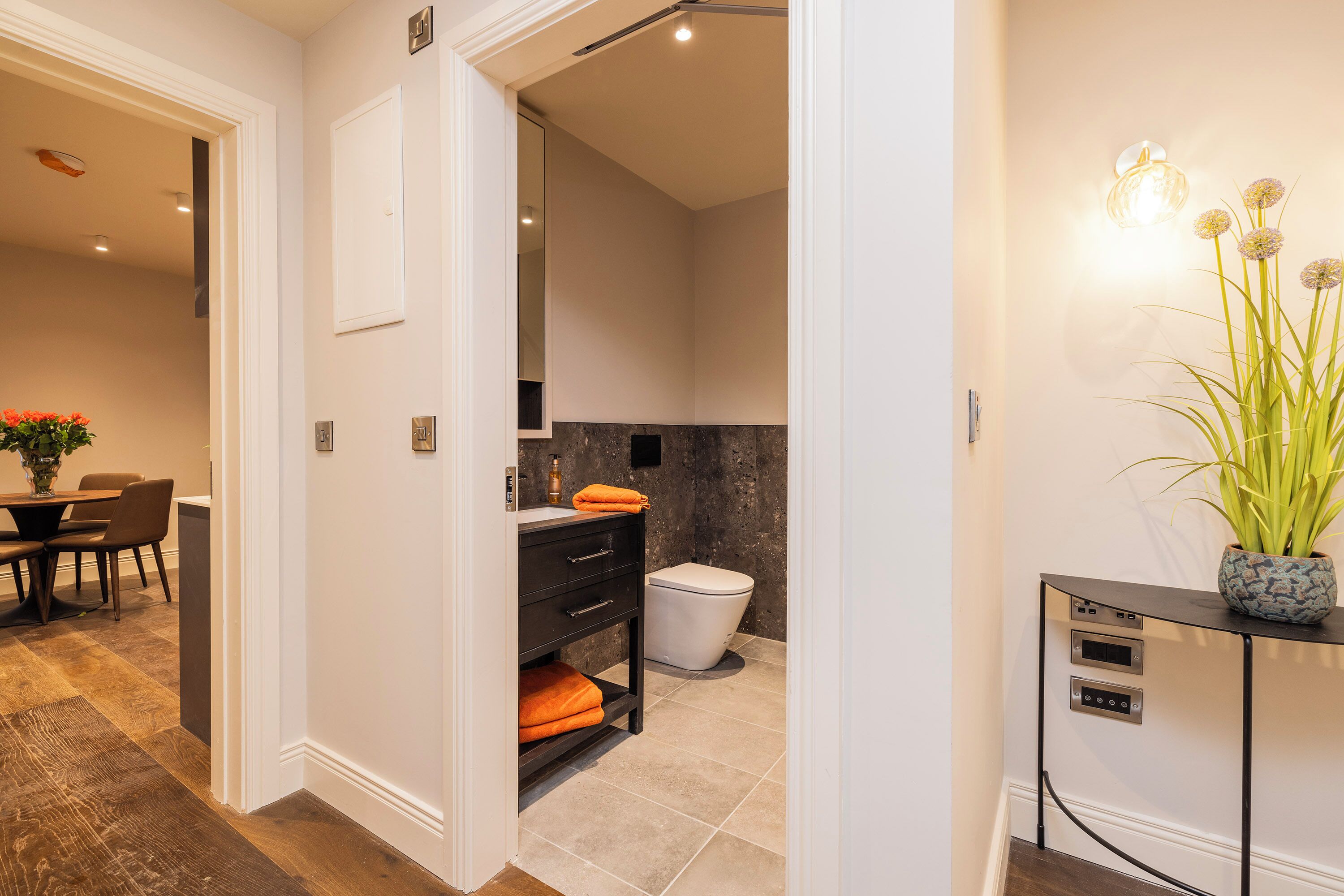 A modern bathroom with a toilet, sink, and a vanity with drawers.