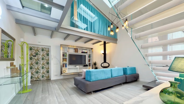 A modern living room with a grey sofa, a flat-screen TV, and a glass staircase. - Luxury Vatican Penthouse with 2 terraces & hot-tub (Roma)