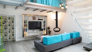 A modern living room with a grey sofa, a flat-screen TV, and a bookshelf. - Luxury Vatican Penthouse with 2 terraces & hot-tub (Roma)