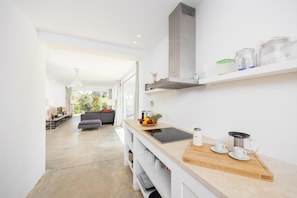 A modern kitchen with a wooden countertop, a built-in stove, and a large window. - Villa Voukithro - Four Bedroom Villa, Sleeps 8 (Ionian Islands)