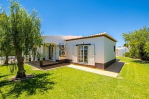 Stunning two-story residence with a well-manicured lawn and mature tree.