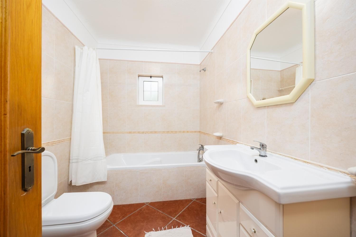 A bathroom with a toilet, bathtub, and sink.
