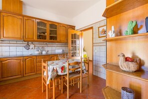 Enjoy meals in this cozy kitchen with a dining table, sink, stove, and ample storage.