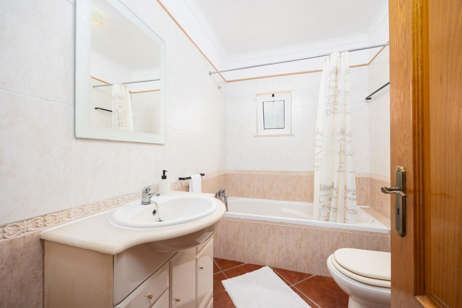 Un bagno con lavandino, specchio, vasca e water.