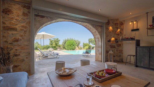 Un espace repas avec vue sur une piscine et des sièges à l'extérieur.