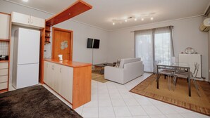 A compact living space with a kitchenette, a dining area, and a seating area.
