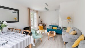 Un salon moderne comprenant un coin repas, un ensemble de canapés et une table basse.