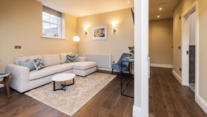 A modern living room with a sectional sofa, a coffee table, and a blue armchair. - Spacious 1 Bed Loft Apartment in Dublin City Centre (Dublin)