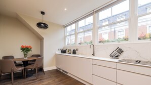A modern kitchen with a dining area, large windows, and a view of the neighborhood. - Spacious 1 Bed Loft Apartment in Dublin City Centre (Dublin)