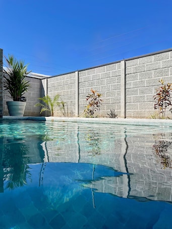 Una piscina al aire libre, camas de piscina gratis, sombrillas