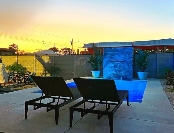 Una piscina al aire libre, camas de piscina gratis, sombrillas