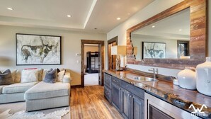 A modern kitchen with a large mirror, wooden cabinets, and a built-in oven. - The BEST Ski In/Out! Immediately next to Montage! (Big Sky)