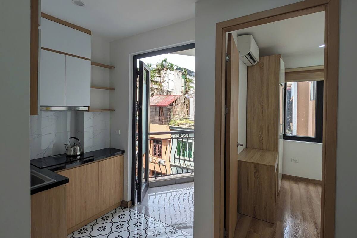 A modern kitchen with wooden cabinets, a black countertop, and a patterned floor.