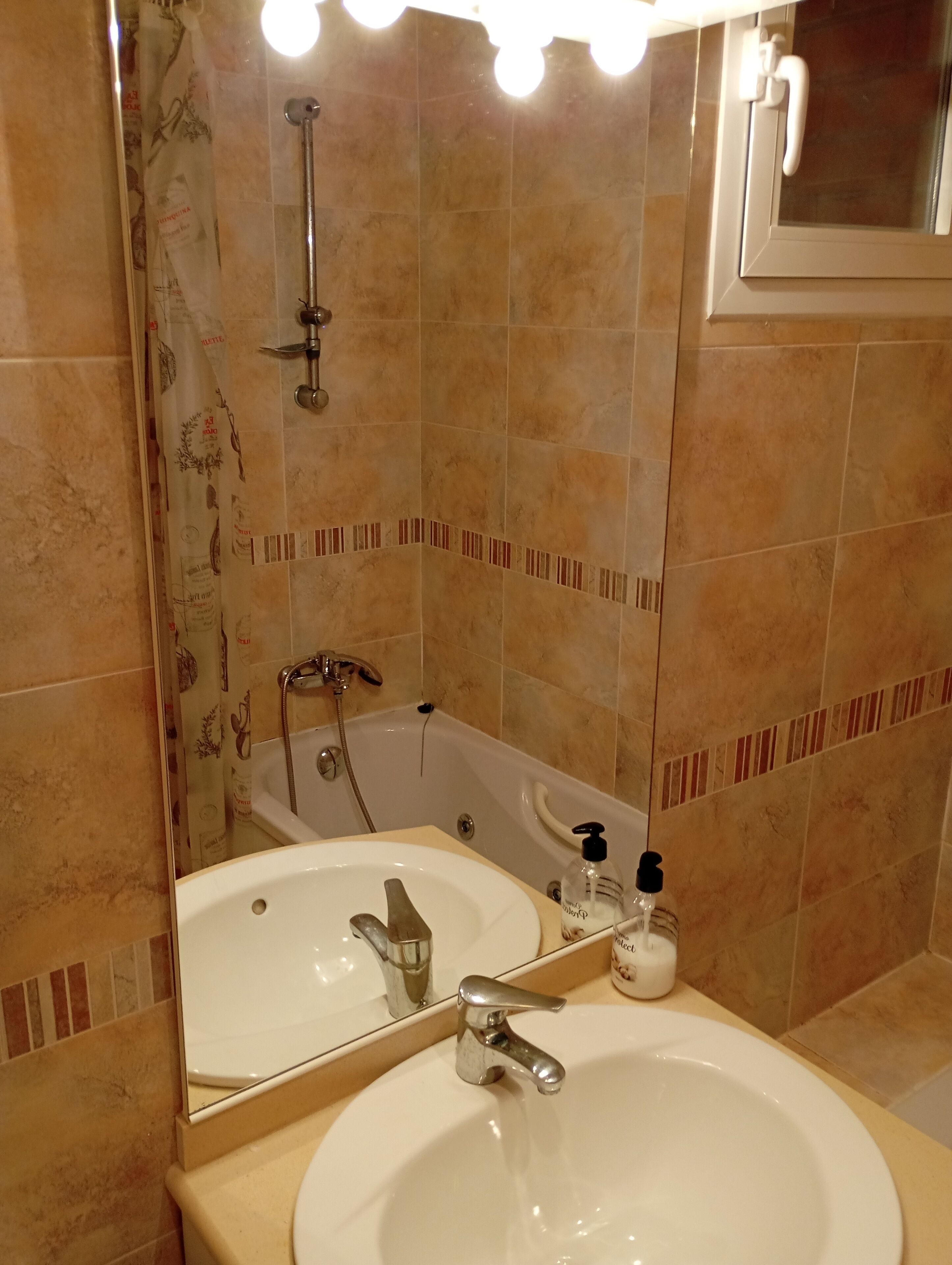 A bathroom with a bathtub, a sink with a mirror, and a shower.