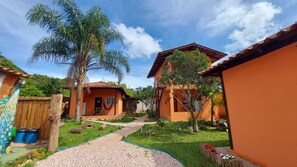 Un patio con dos casas, una palmera y un camino de grava.