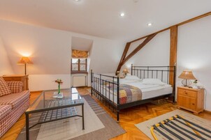 Un dormitorio acogedor con cama, una mesita de vidrio, un armario de madera y una ventana.