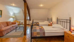 Une chambre confortable avec deux lits, un canapé, une petite table et une lampe.