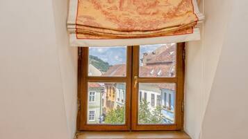 Ein Fenster mit Blick auf Gebäude und eine Hügelkette.