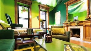 Un salon chaleureux avec une cheminée, des murs verts et un canapé confortable.