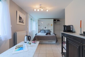 A bedroom with a bed, bedside table, and a view of the bathroom. - Annexe du Petit Echo de la mode – Nature Gîte with Private Garden, Billiards, Wi-Fi, Wood Stove (Plélo)
