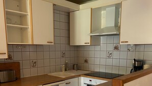A kitchen with white cabinets, a wooden countertop, a dishwasher, and a stove. - Apartment 'La Sétaz' with Mountain View, Private Terrace and Wi-Fi (Valloire)