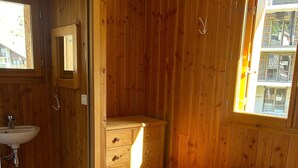 A wooden room with a bed, a wooden dresser, a mirror, and a window. - Apartment 'La Sétaz' with Mountain View, Private Terrace and Wi-Fi (Valloire)