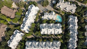 An aerial view of a residential area with multiple houses featuring modern, geometric roofs.