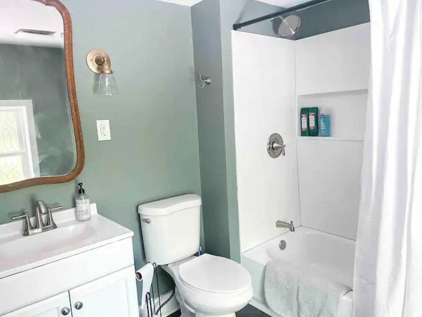 Ein Badezimmer mit Toilette, Waschbecken, Spiegel und Dusche.