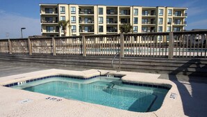 A swimming pool with a 3 FT depth marker, surrounded by a concrete deck and a wooden fence. - Bermuda Run 103A-2BR-Pool, Hot Tub (North Myrtle Beach)
