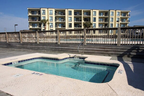 A swimming pool with a 3 FT depth marker, surrounded by a concrete deck and a wooden fence. - Bermuda Run 103A-2BR-Pool, Hot Tub (North Myrtle Beach)