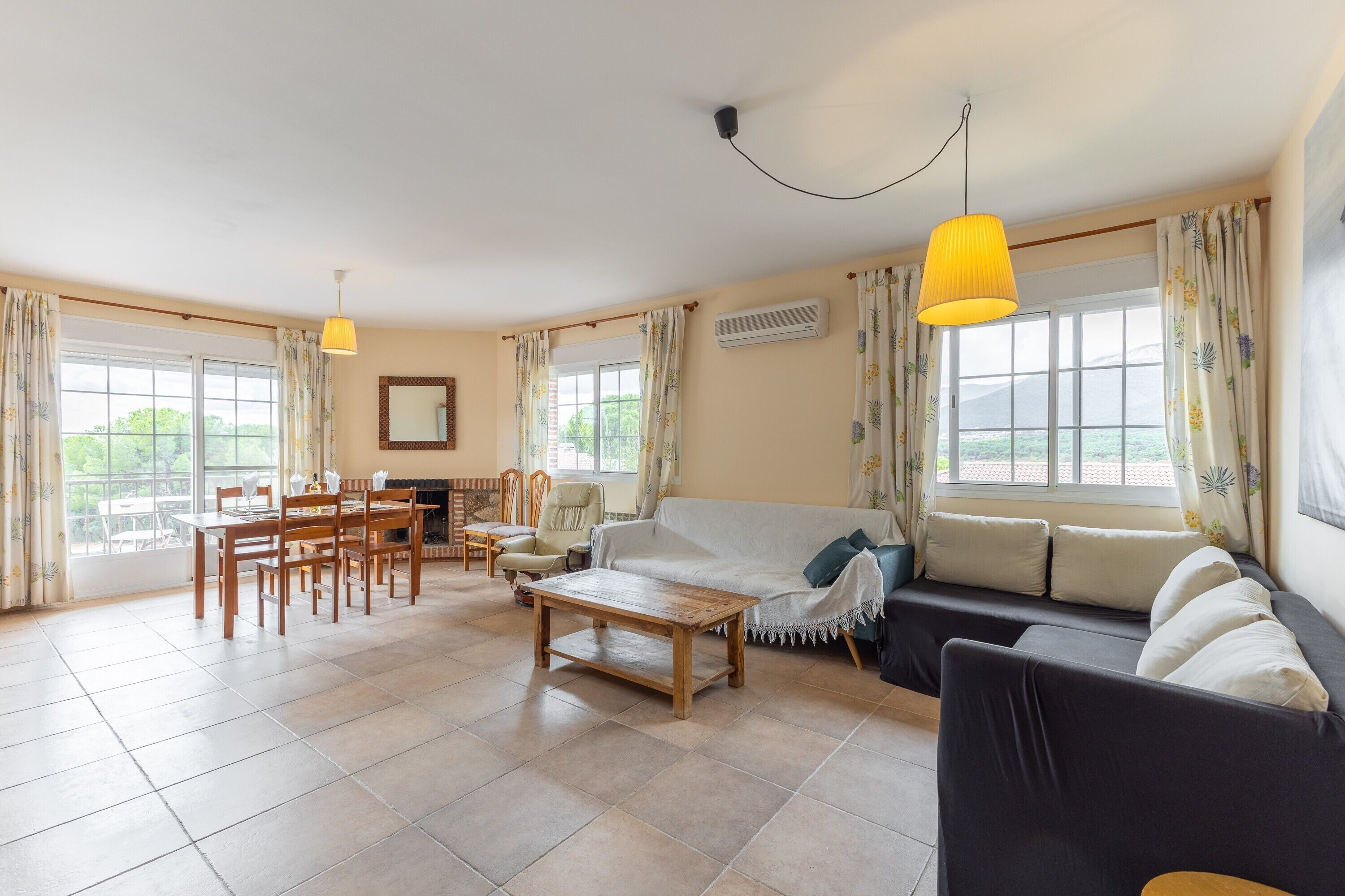 A spacious living area with a sofa, dining table, chairs, and a coffee table.