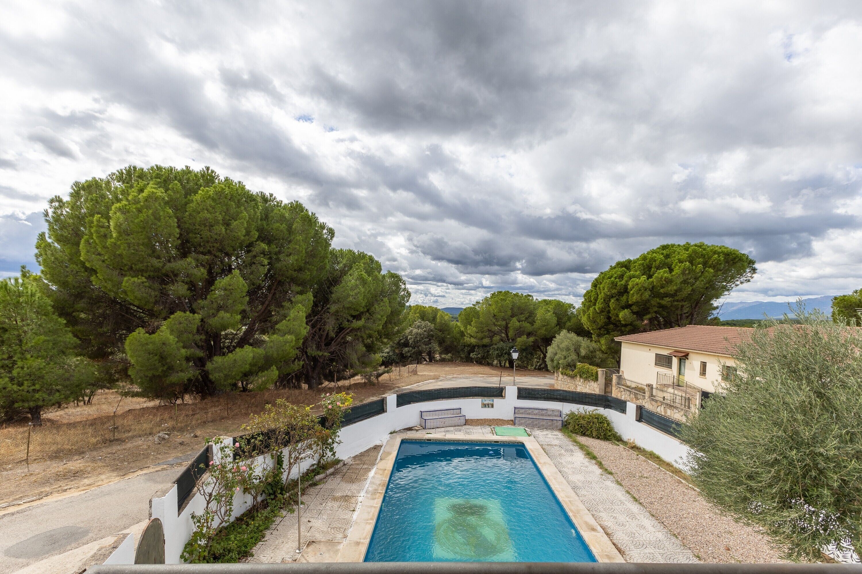 Une piscine entourée d’arbres et un bâtiment.