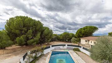 Une piscine entourée d’arbres et un bâtiment.