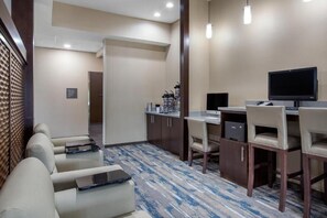 Relax in a spacious room with a comfortable seating area, desk, and kitchenette.