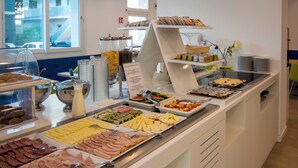 A buffet with various food options including meats, cheeses, and fruits.